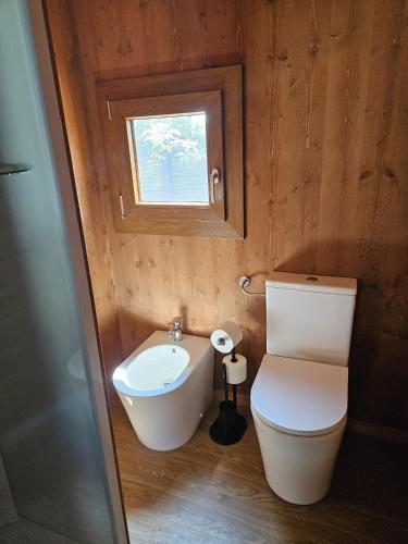 a small bathroom with a toilet and a window at Vicolungo Glamour Lodge & SPA - Free SPA Hot Tub e Sauna in Vicolungo