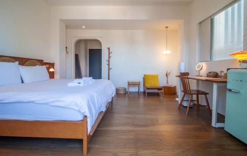 a bedroom with a bed and a desk and a kitchen at Soli Inn 宿里旅行舍 in Hualien City