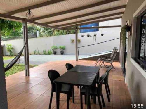 a dining area with a table and chairs on a patio at casa jardim Eliza in Foz do Iguaçu