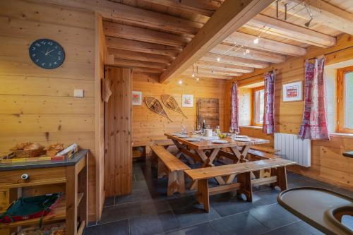 une salle à manger avec des murs en bois et une horloge au mur dans l'établissement Chalet L'Orcières, Spa Privé et Charme Montagnard, à Béranger