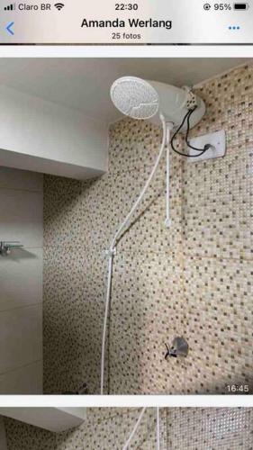 a bathroom with a shower with a spider on the wall at casa jardim Eliza in Foz do Iguaçu