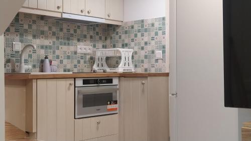 a kitchen with white cabinets and a stove top oven at Emerald Blue in Skiathos Town