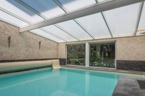 an indoor swimming pool with a skylight at Villa Alba avec piscine et Spa in Metz