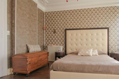 une chambre avec un grand lit et une commode dans l'établissement Villa Alba avec piscine et Spa, à Metz