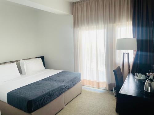 a bedroom with a bed and a desk and a window at Hotel Petit Palais in Venice-Lido