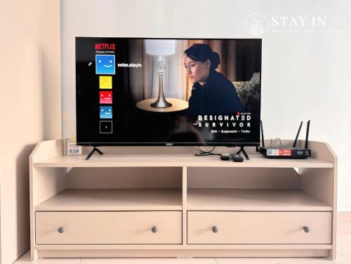 a tv on top of a white entertainment center at Pinnacle PJ - Free Parking, LRT, WiFi, Netflix in Petaling Jaya