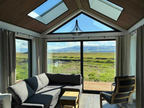 a living room with a couch and a large window at Infinity Horizons in Hvolsvöllur