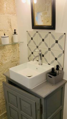 une salle de bain avec un lavabo blanc et un miroir dans l'établissement La demeure, à Aigues-Vives