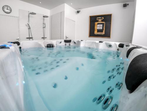 a hot tub with blue water in a room at Les Lys d'Or Appartement avec Jacuzzi in Saumur