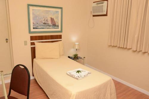 a small bedroom with a bed with a plate on it at Skalla Hotel Nova Odessa in Nova Odessa