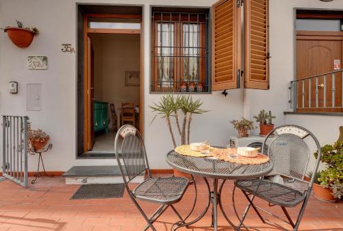 un patio con tavolo e sedie davanti a una casa di A casa di Greta a Prato
