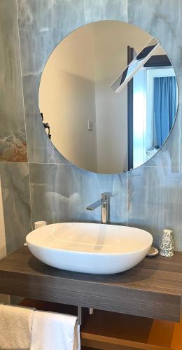 a bathroom with a white sink and a mirror at Hotel Petit Palais in Venice-Lido