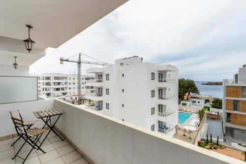 a balcony with chairs and a view of a building at Apartamentos Esmeralda Ibiza in Ibiza Town