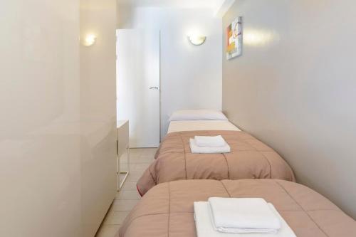 a room with three beds with towels on them at Apartamentos Esmeralda Ibiza in Ibiza Town