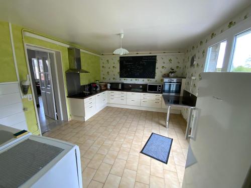 - une cuisine avec des murs verts et des placards blancs dans l'établissement Chez Marguerite, à Auchy-la-Montagne