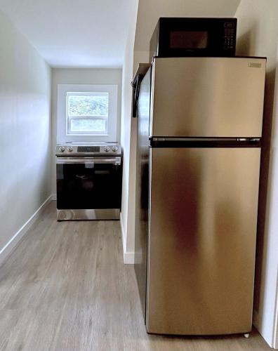 a kitchen with a stainless steel refrigerator and a stove at Chic, Cozy & New Prime location with AC, Street Parking #4 in Renton