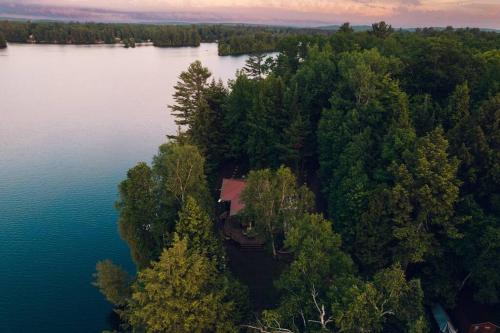 an aerial view of a house on the shore of a lake at Grinmore Lakehouse with Panoramic View & Hot Tub in Emsdale