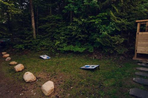 two ping pong tables in a yard with rocks at Grinmore Lakehouse with Panoramic View & Hot Tub in Emsdale