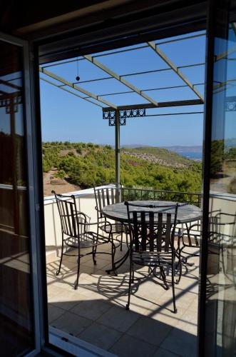 a table and chairs on a balcony with a view at Villa Pepy in Áyios Konstandínos