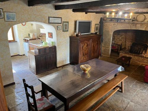 - un salon avec une table en bois et une cheminée dans l'établissement L'Écrin Champêtre, gîte à la campagne, à Saint-Affrique