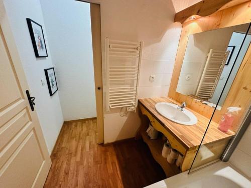 une salle de bain avec un lavabo et un miroir dans l'établissement Les 3 Vallées, Appartement Montagnard avec Spa et Piscine, à Orelle