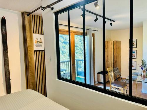 un miroir dans une chambre avec vue sur un balcon dans l'établissement Les 3 Vallées, Appartement Montagnard avec Spa et Piscine, à Orelle