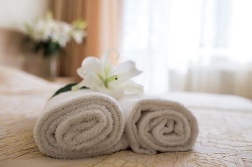 een paar handdoeken bovenop een bed bij Hotel SPA Arkadia in Apšuciems