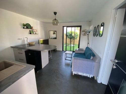 une cuisine et un salon avec une table et un canapé dans l'établissement Nantes sud Loire St Sebastien Sur LoireMaison T 2, à Saint-Sébastien-sur-Loire