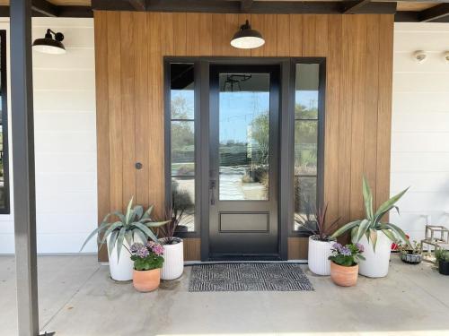 a front door of a house with potted plants at Black Barn Ranch 25 Acres Wpool Near Downtown in San Luis Obispo