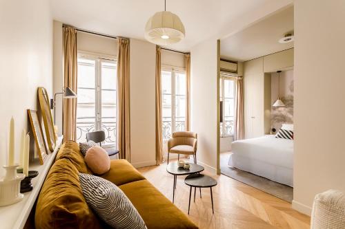 un salon avec un canapé et un lit dans l'établissement Habitat Parisien - Grands Boulevards Montorgueil, à Paris