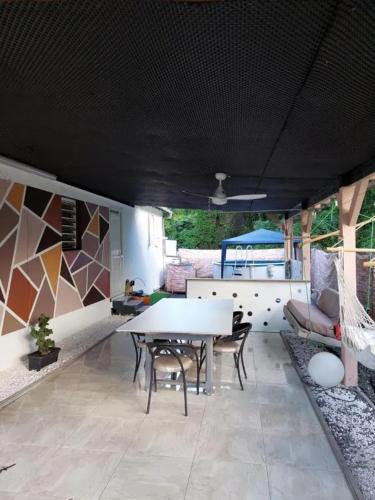 a dining room with a white table and chairs at Maison familiale avec piscine à Baie-Mahault - 120 m² - 8 pers in Baie-Mahault