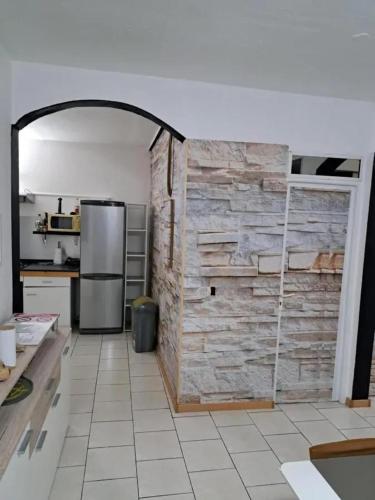 a kitchen with a stone wall and a refrigerator at Maison familiale avec piscine à Baie-Mahault - 120 m² - 8 pers in Baie-Mahault