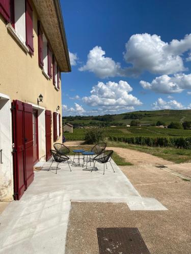 un patio avec des chaises et une table devant un bâtiment dans l'établissement Les Hirondelles De Fuiss, à Fuissé