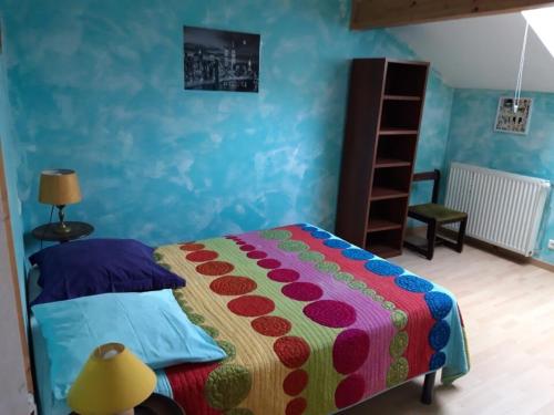 - une chambre avec un lit doté d'un couvre-lit coloré dans l'établissement T4 Duplex Hypercentre Pont De Vaux, à Pont-de-Vaux