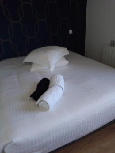 - un lit blanc avec une serviette et des oreillers dans l'établissement Blue Swallow-fuiss, à Fuissé