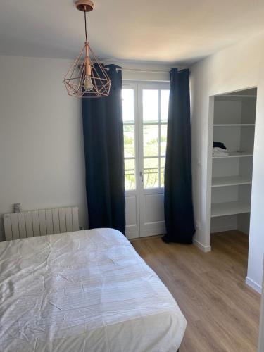 a bedroom with a bed and a window with blue curtains at Blue swallow-Fuissé in Fuissé