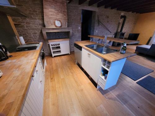 une cuisine avec un évier et un plan de travail dans l'établissement Les Jyrondelles Prisse Family House, à Prissé