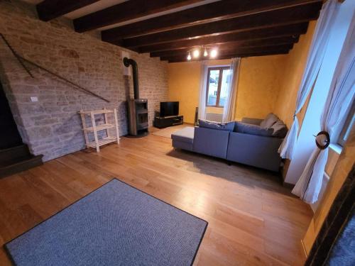 un salon avec un canapé et une télévision dans l'établissement Les Jyrondelles Prisse Family House, à Prissé