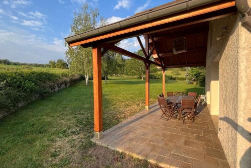 patio ze stołem i krzesłami pod dachem w obiekcie Holiday Home Maizeray Saint Martin Du Tartre w mieście Saint-Martin-du-Tartre