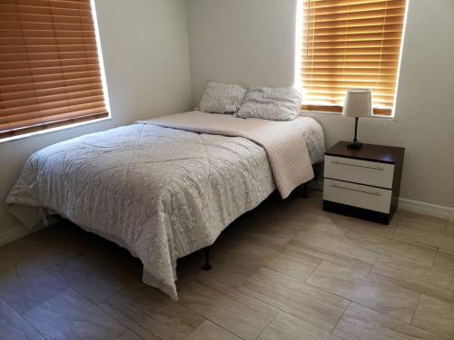 Un dormitorio con una cama y una mesa con una lámpara. en Cozy home Southside Jax, en Jacksonville