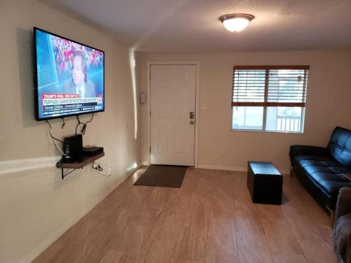 Una sala de estar con un sofá y un televisor de pantalla plana. en Cozy home Southside Jax, en Jacksonville