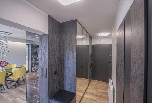 a room with a glass partition with a table and chairs at Apartament w Cieplicach Elegant in Jelenia Góra