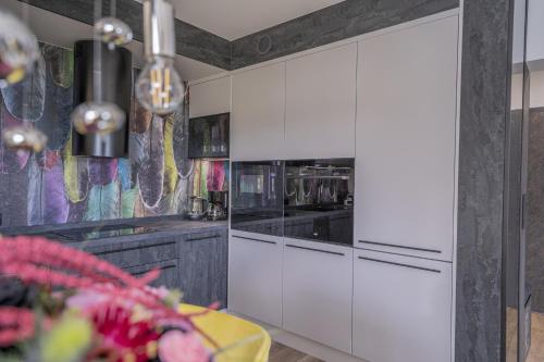 a kitchen with white cabinets and a table in it at Apartament w Cieplicach Elegant in Jelenia Góra
