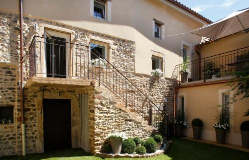 un bâtiment en pierre avec une porte et quelques plantes dans l'établissement La Maison De Marius Saint Amour Bellevue, à Saint-Amour-Bellevue