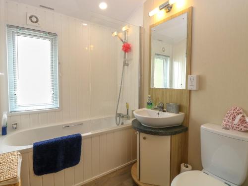 a bathroom with a sink and a tub and a toilet at 21 Norman Drive Lodge in Great Yarmouth