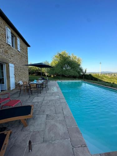 - une piscine avec des tables et des chaises à côté d'un bâtiment dans l'établissement Maison Stirling Bourgogne Sleeps 8 Pool, à Saint-Julien-de-Civry