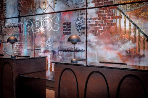 a room with a table and a wall covered in graffiti at The Cloud One Hamburg-Kontorhaus in Hamburg