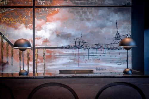 a window with a painting of a harbor at The Cloud One Hamburg-Kontorhaus in Hamburg