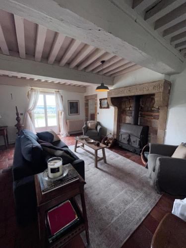 un salon avec un canapé et une cheminée dans l'établissement Maison Stirling Bourgogne Sleeps 8 Pool, à Saint-Julien-de-Civry
