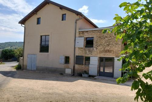 un ancien bâtiment en pierre avec deux portes de garage dans l'établissement At The End Of The World -bussieres Burgundy, à Bussières